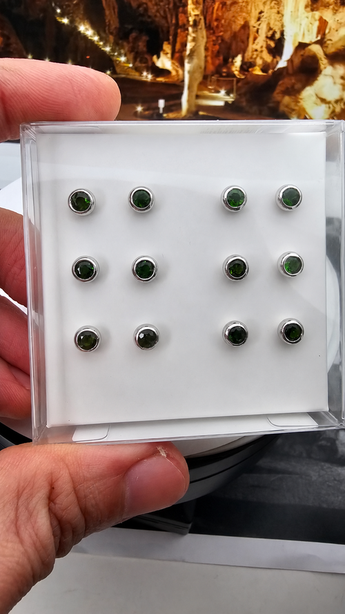 Hand-held box displaying 6 pairs of chrome diopside ear studs in 925 sterling silver, with the handwritten label retouched. Sold per pair.