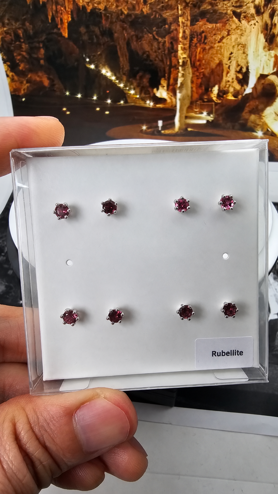 Hand-held display box containing four pairs of 4 mm round rubellite tourmaline studs in six-claw 925 sterling silver settings, with handwritten sticker removed. Sold per pair.