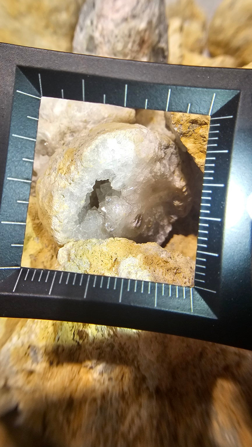 Close view of the marked scale on The Gem Museum magnifier over a geode specimen